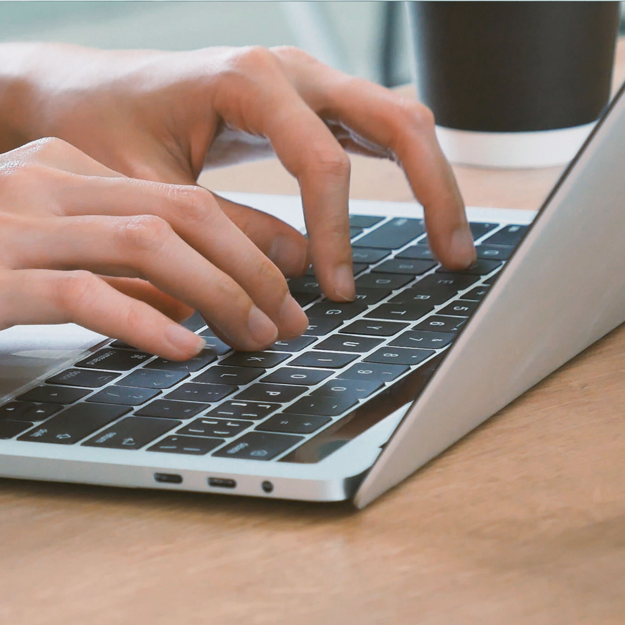 Image of a laptop with typing hands